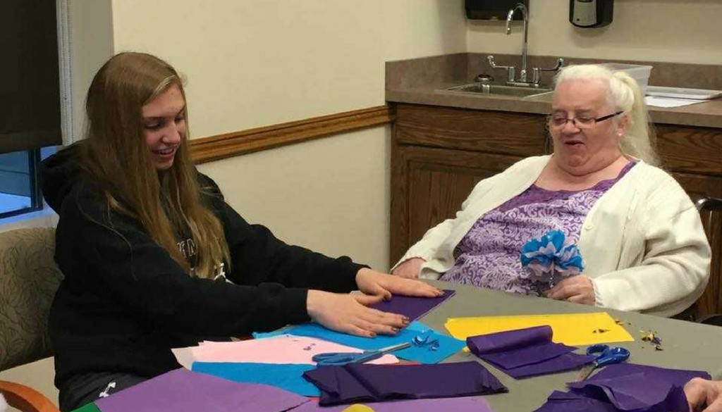 A volunteer assisting a resident with crafting at The Neighbors of Dunn County.