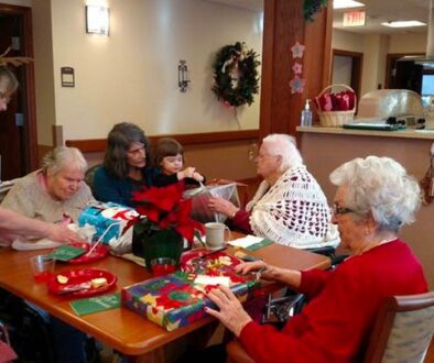 Residents and family opening Christmas presents together at The Neighbors of Dunn County.
