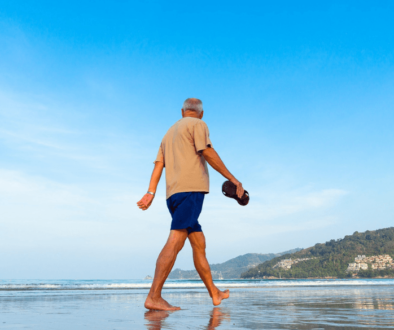 A Senior walking on the beach barefooted
