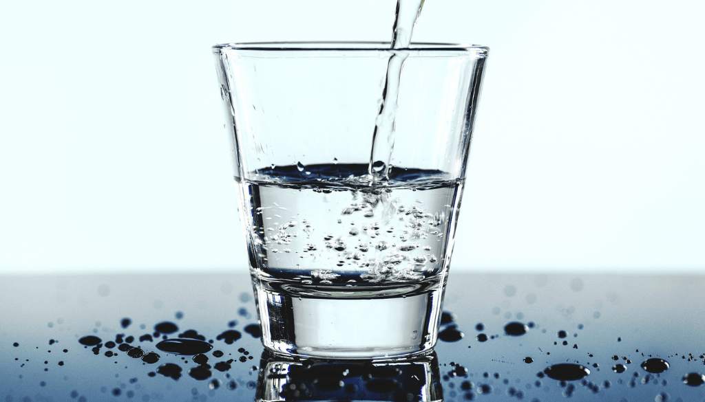A drinking glass being filled with water.