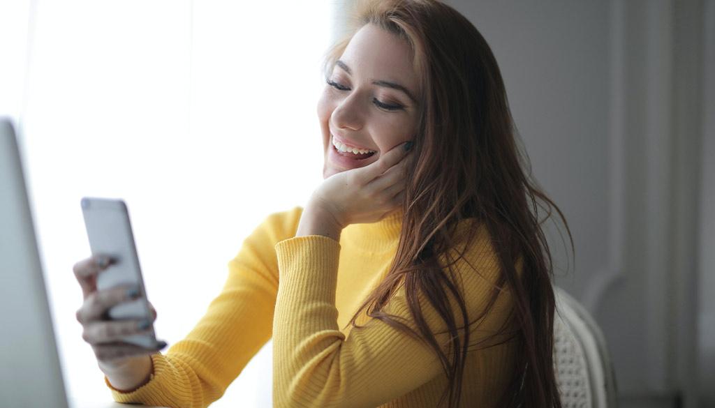 A young women facetiming on her phone.