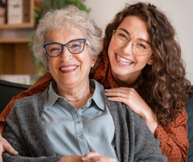 Senior agedd woman being hugged by woman in her 30's. The Neighbors of Dunn County how seniors can maintain relationships in caregiving facilities.