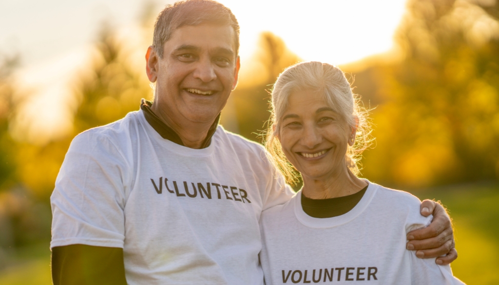 A couple wearing "volunteer" t-shirts at sunset.