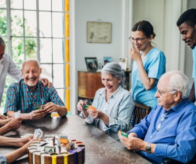 Elderly people in a nursing home smile while playing a game.