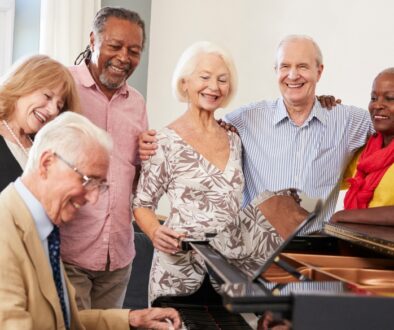 Senior citizens partaking in music therapy by watching a peer play piano.