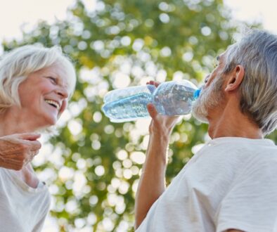A man drinks water while enjoying a summer day with his wife.