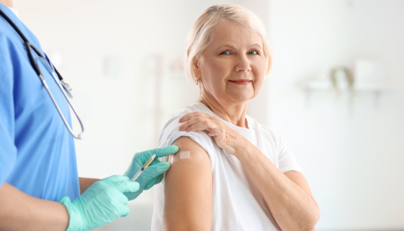 Older woman receives a vaccine from a nurse after learning about the importance of immunizations for older adults.