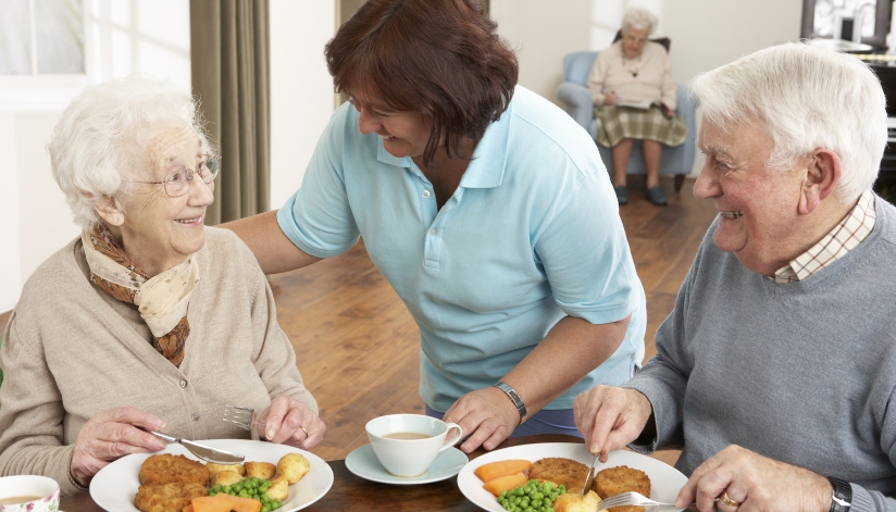 Dietician talks with two seniors about their eating habits over a meal during Malnutrition Awareness week.